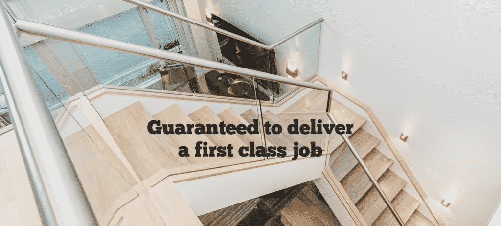 Top-down view of a modern staircase with glass railings and wooden steps, featuring wall-mounted lighting and a bold text overlay stating 'Guaranteed to deliver a first-class job' by Sayers Contracting.