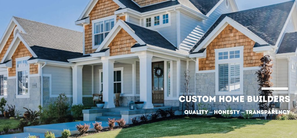 Custom-built modern farmhouse with stone and cedar shake siding, a welcoming front porch, and landscaped yard.