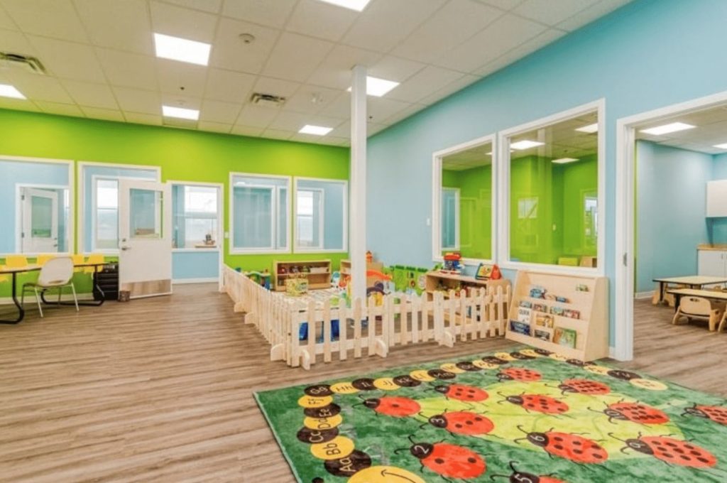 Bright and colorful daycare or preschool interior with play areas, learning stations, and child-friendly furniture.