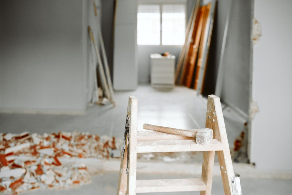 renovation work with a hammer sitting on a ladder